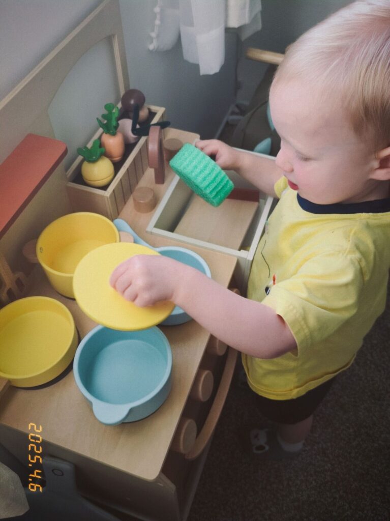 toddler in a play kitchen
