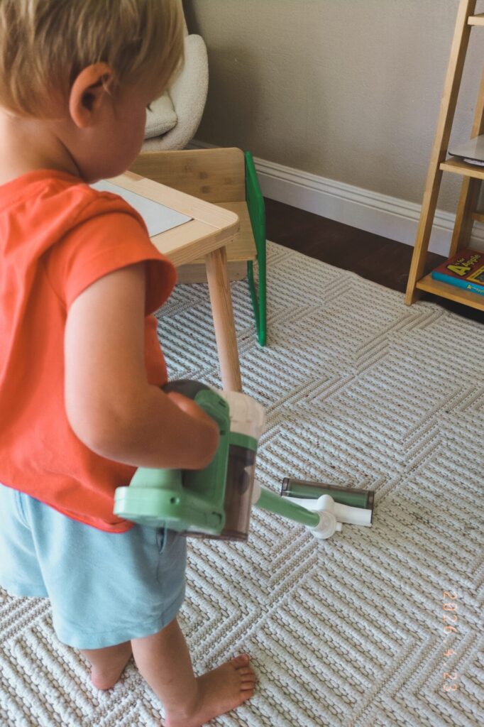 Child using a toy vacuum