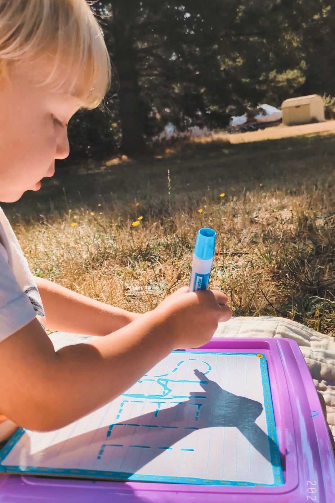 Boy practicing his preschool letters outside