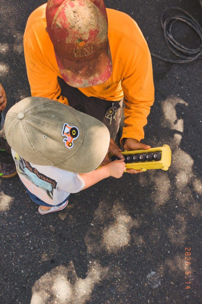Preschool aged boy being shown a tool from a community helper