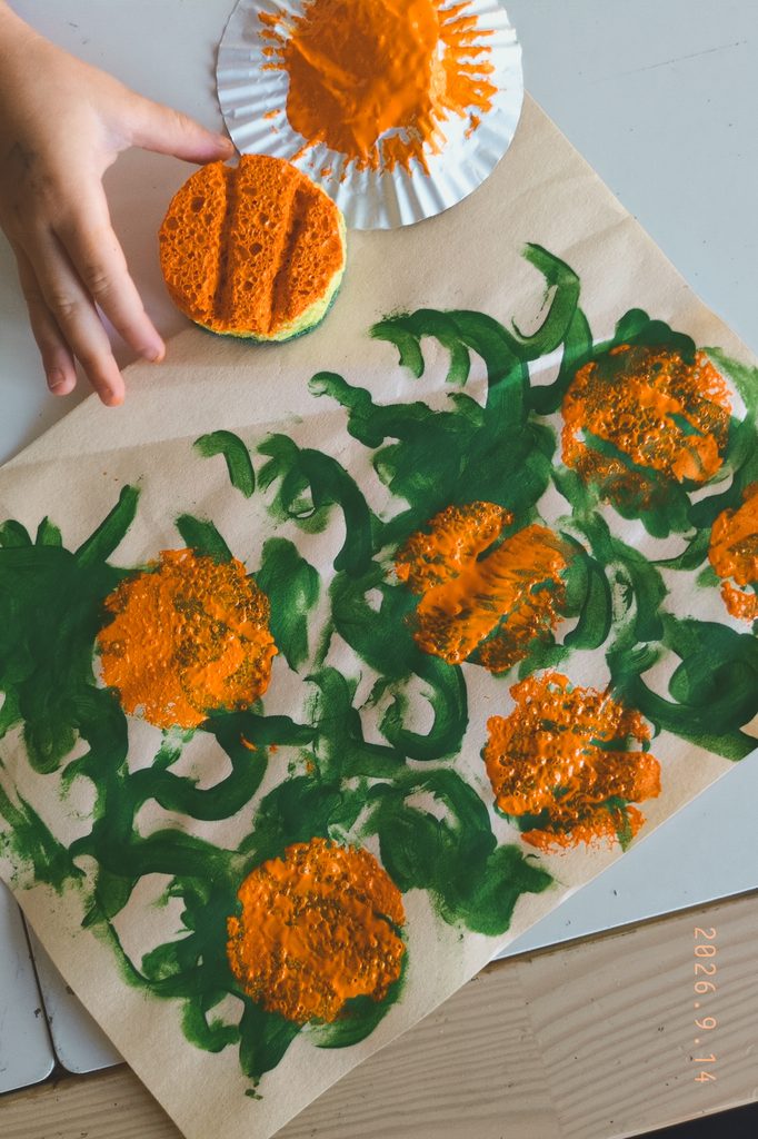Boy making paint stamped pumpkins