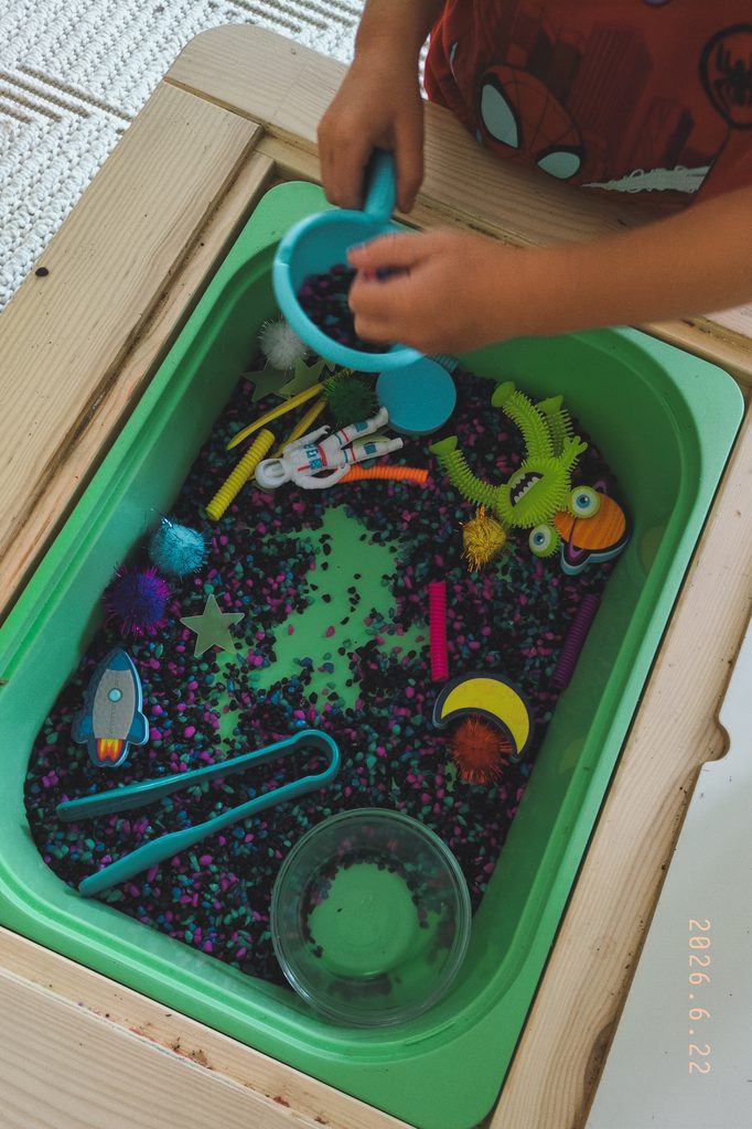 toddler playing in a sensory table