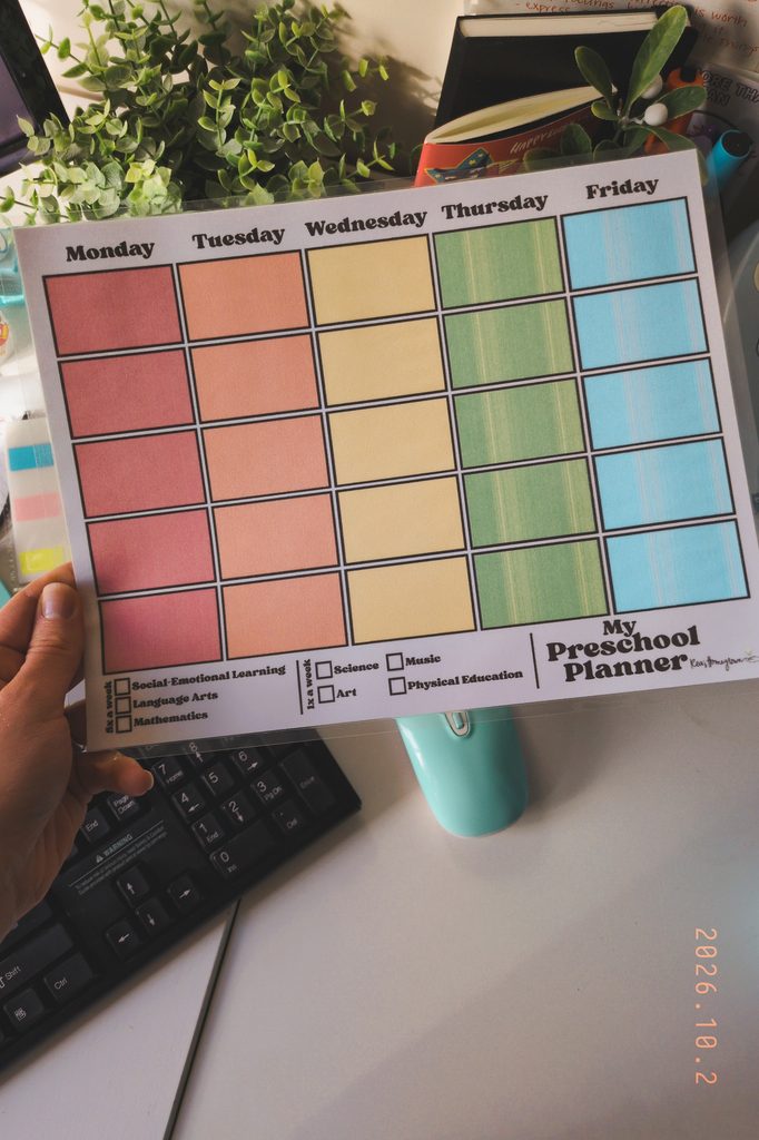 weekly preschool planner being held